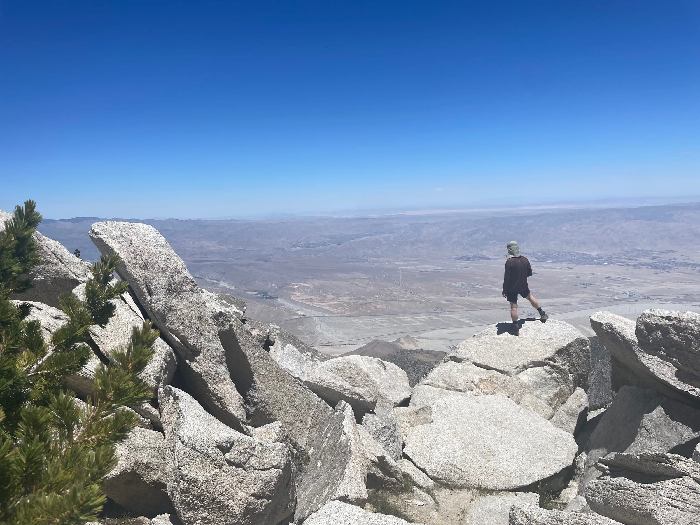 Person on mountain summit overlooking desert